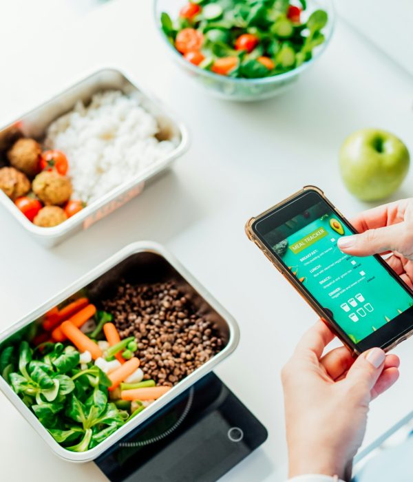 Healthy diet plan for weight loss, daily ready meal menu. Woman using meal tracker app on phone
