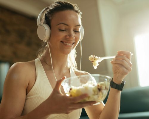 Young smiling athlete enjoying in healthy food at home.